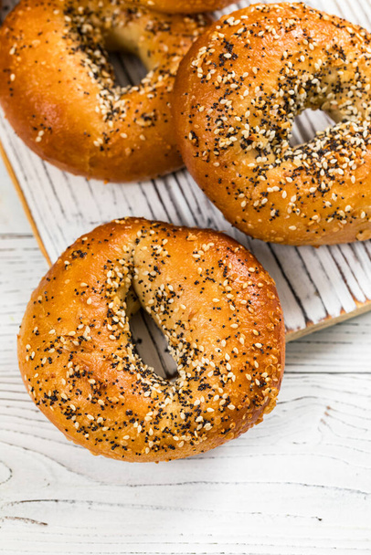 Freshly Baked Bagels Topped with Sesame Seeds, Poppyseeds, Garlic and Onion. Selective focus. - Fotografie, Obrázek
