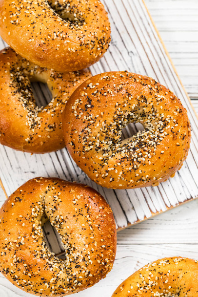 Freshly Baked Bagels Topped with Sesame Seeds, Poppyseeds, Garlic and Onion. Selective focus. - Foto, Bild