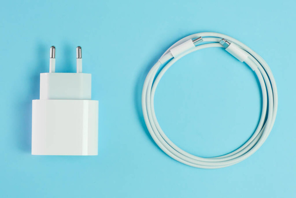 Ein weißes Smartphone-Ladekabel mit blitzschnellem USB-A-Anschluss und Adapter. - Foto, Bild