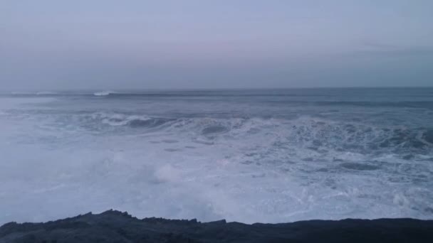 Des vagues géantes s'écrasent contre les rochers et libèrent de grandes quantités de mousse blanche - Séquence, vidéo