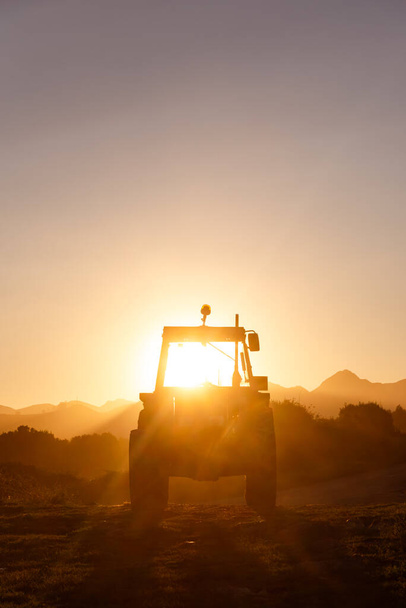 tractor stopped at sunset after workday. the sun breaks through the cabin. concept of industry and rural environment. - 写真・画像