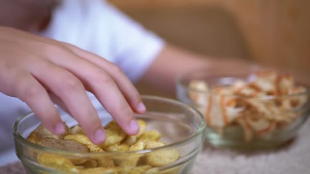 Kid Hand bierze chipsy, krakersy z talerza. Jedzenie ze szkodliwe przekąski Foods - Materiał filmowy, wideo
