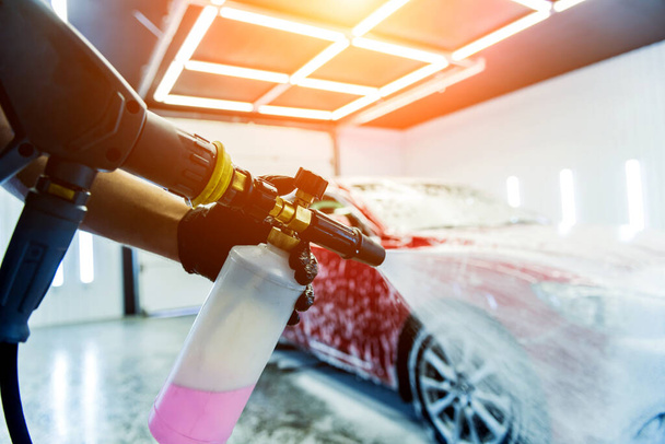 Worker washing car with active foam on a car wash. - Foto, Imagem