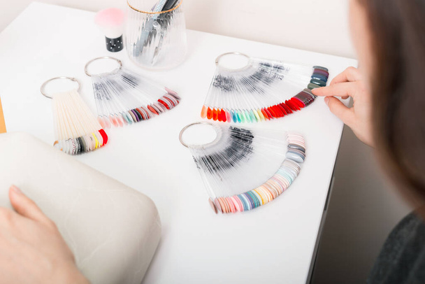 Женщина в салоне выбирает цвет из цветовой палитры - Фото, изображение