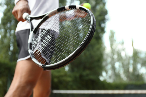 Sportsman playing tennis at court on sunny day, closeup - Fotoğraf, Görsel