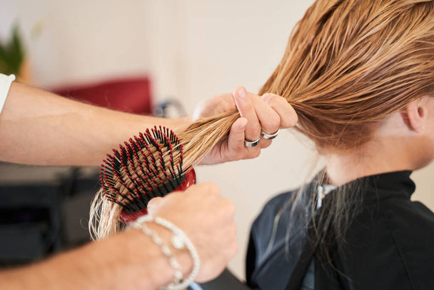 Professional hairdresser styling the hair - Фото, зображення