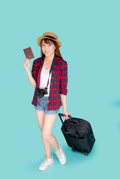 Krásná mladá asijská žena s úsměvem a cestování letní výlet se zavazadly a držení pasu pro zahraničí v dovolené, šťastná asijské dívka s kamerou chůze a vytáhnout kufr na cestu do dovolené. - Fotografie, Obrázek