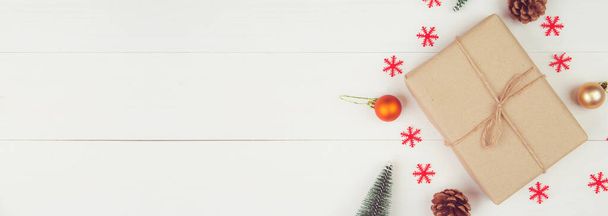 Χριστουγεννιάτικη σύνθεση με διακόσμηση δώρου σε ξύλινο φόντο, νέο έτος και Χριστούγεννα ή επέτειο με δώρα σε ξύλινο τραπέζι σε εποχή, κορυφαία θέα ή επίπεδη lay, αντίγραφο χώρου, banner ιστοσελίδα. - Φωτογραφία, εικόνα