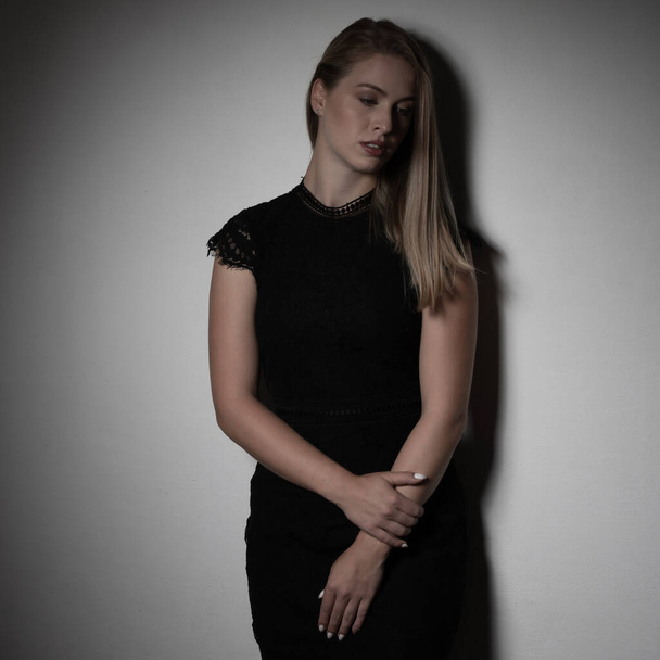 Dramatic studio portrait of beautiful young woman on dark background. - Φωτογραφία, εικόνα