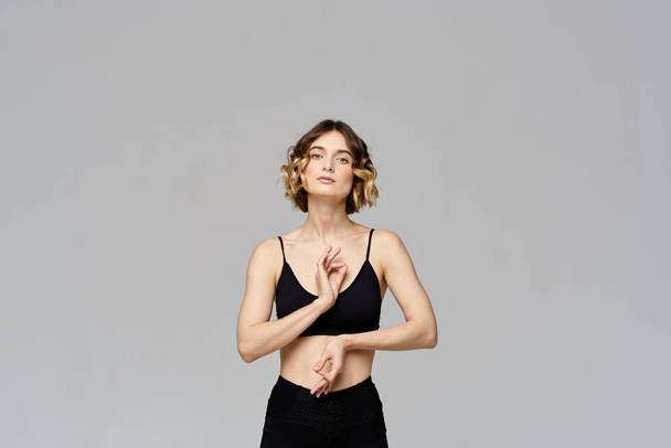 woman gesturing with her hands slim figure meditation sport gray background - Photo, image
