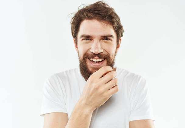 Energetic man in white t-shirt bushy beard gestures with hands cropped view - Photo, Image