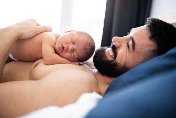 father lay on bed with his newborn baby daughter - Фото, зображення