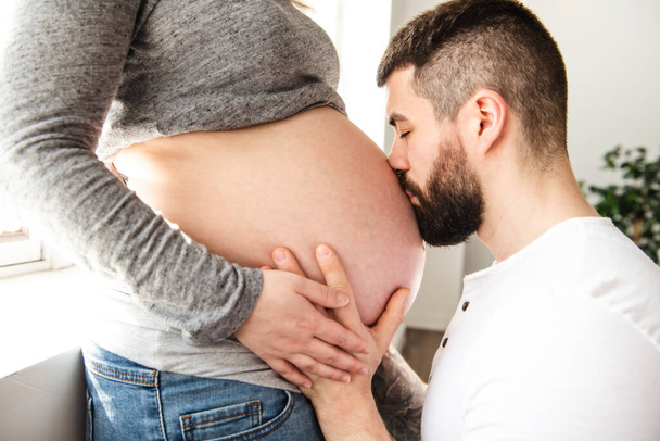A Beautiful pregnant woman and her handsome husband close look t the belly - Zdjęcie, obraz