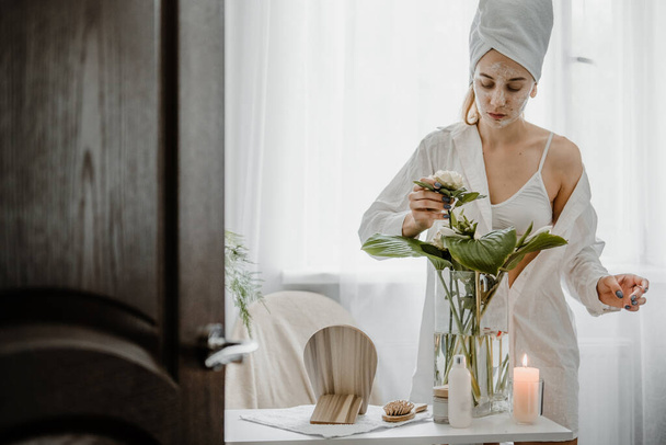 Self Care Ideas for woman. Beauty Self Care Routine, Ways to Reduce Stress, increase mindfulness and avoid burnout. Young woman in white towel chilling in bedroom and do her beauty Self Care Routine - Photo, Image