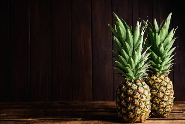 Fresh ripe juicy pineapples on wooden table. Space for text - 写真・画像