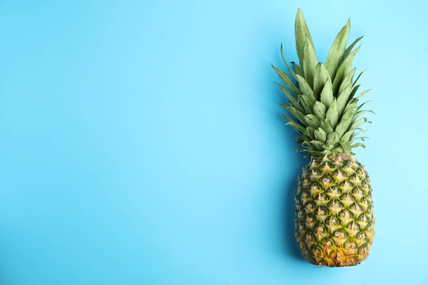Fresh ripe juicy pineapple on light blue background, top view. Space for text - Фото, изображение