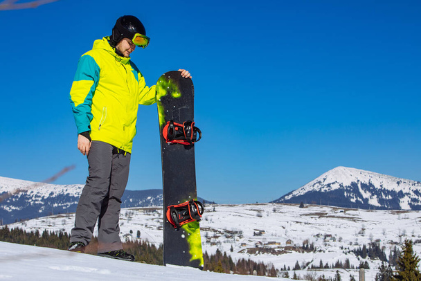 man in sunglasses holding snowboard - Foto, afbeelding