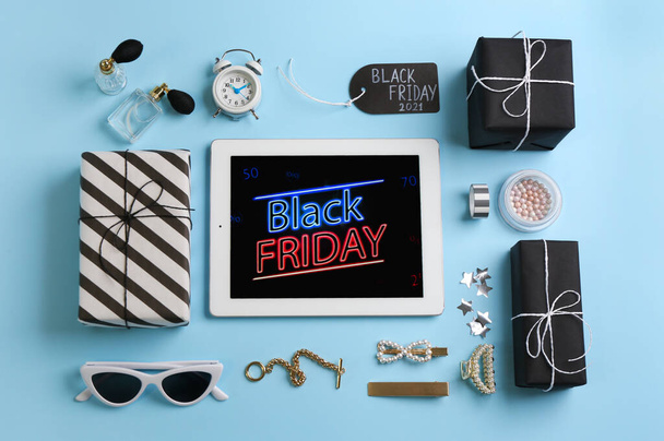 Flat lay composition with tablet, gifts and accessories on light blue background. Black Friday sale - Foto, imagen