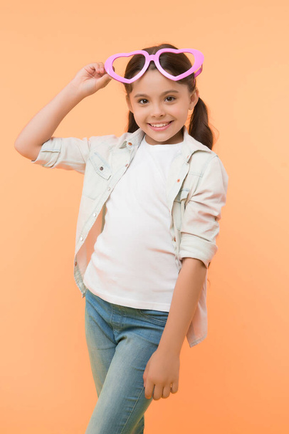 Be my valentine. Child charming smile yellow background. Kid happy lovely feels sympathy. Kid girl heart shaped eyeglasses celebrates valentines day. Girl adorable smiling face heart glasses - Φωτογραφία, εικόνα