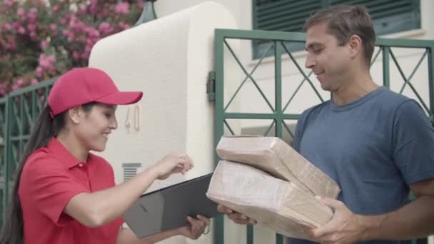 alegre mensajero chica en rojo cap entrega paquete - Metraje, vídeo
