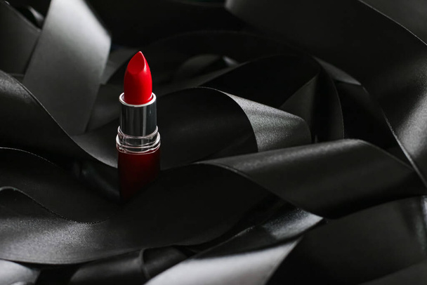 Κόκκινο κραγιόν σε μαύρο μεταξωτό φόντο, πολυτελές μακιγιάζ και καλλυντικών ομορφιάς - Φωτογραφία, εικόνα