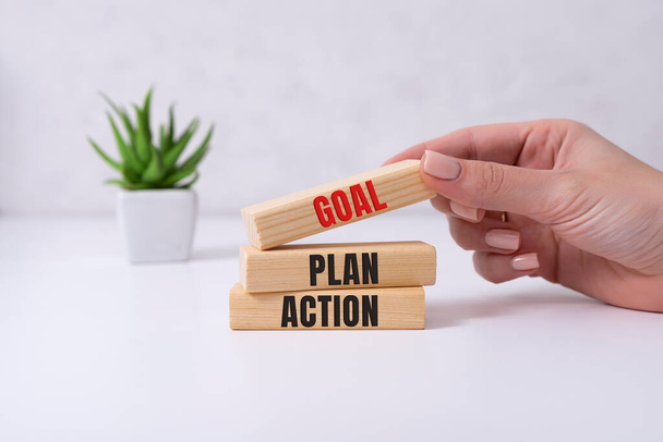 Goal,plan,action text on wooden cubes with hand .Business motivation or inspiration,performance of human concepts ideas - Photo, Image