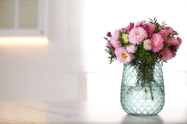 Vase with beautiful chrysanthemum flowers on table in kitchen, space for text. Interior design - Valokuva, kuva