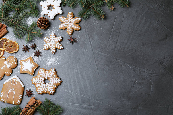 Decorated Christmas cookies and fir tree branches on grey table, flat lay. Space for text - Фото, зображення