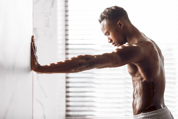 African American Man In Shower Relaxing Standing In Bathroom, Side-View - Foto, imagen