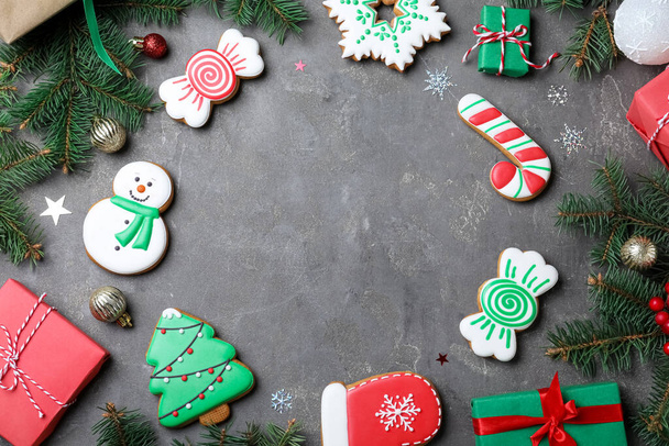 Frame of decorated Christmas cookies and gift boxes on grey table, flat lay. Space for text - Фото, зображення