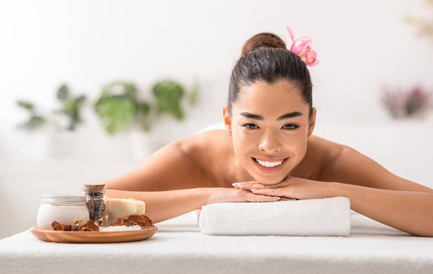 Linda senhora asiática desfrutando de tratamentos de beleza com cosméticos naturais no spa - Foto, Imagem