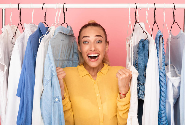 Overjoyed woman screaming with joy choosing clothes - Фото, зображення