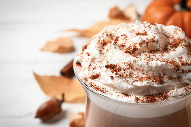 Delicious pumpkin latte on white table, closeup - Φωτογραφία, εικόνα