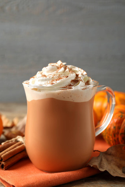 Delicious pumpkin latte with whipped cream on table, closeup - Foto, imagen