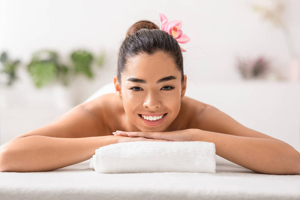 Belle femme asiatique relaxant dans le salon de spa, allongé sur table de massage - Photo, image