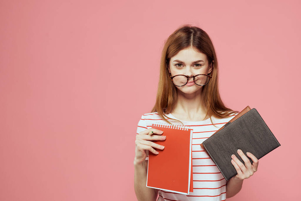 bella studentessa che tiene libri istituto di istruzione gesticolando con le mani sfondo rosa Copia Spazio - Foto, immagini