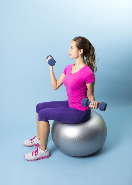 Fitness-Frau stemmt Gewichte auf Medizinball - Foto, Bild