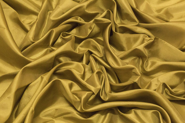 Smooth elegant gold silk or satin luxury cloth texture can use as wedding background. Luxurious Christmas background or New Year background design.Golden Canvas for Background.  - Photo, Image
