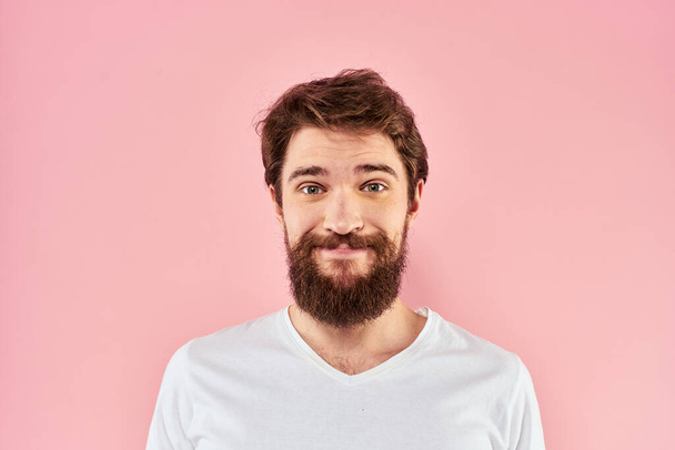 Bearded man white t-shirt cropped view lifestyle studio pink background - Foto, afbeelding