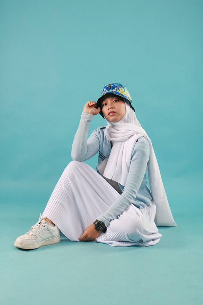 Модний портрет молодої красивої азіатської мусульманки з хіджабом на синьому фоні
 - Фото, зображення