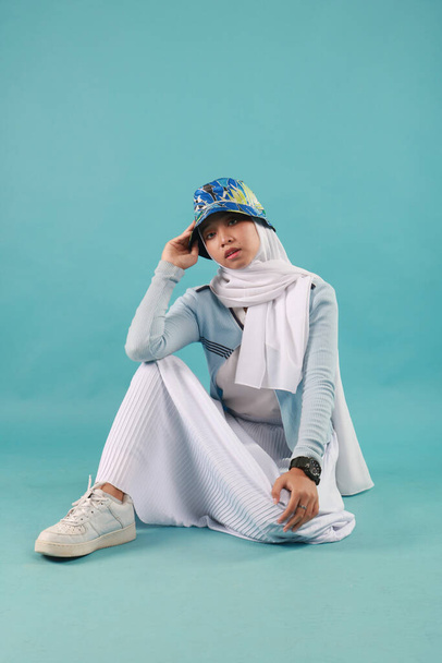 Модный портрет молодой красивой азиатской мусульманки с ношением хиджаба на синем фоне - Фото, изображение