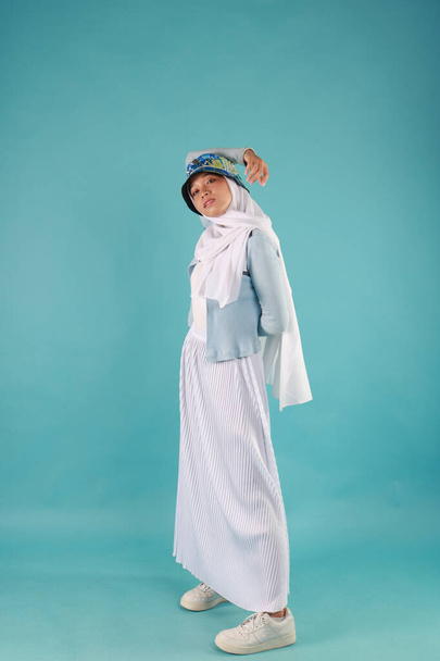 Fashion portret van jonge mooie aziatische moslim vrouw met het dragen van hijab op blauwe achtergrond - Foto, afbeelding