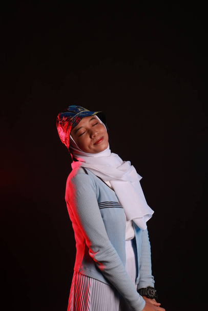 Portrait de mode de jeune belle femme musulmane asiatique avec le port du hijab sur fond bleu - Photo, image