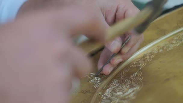 Bukhara mester mintákat vésett a tálcára. Bezárás, lassított felvétel. - Felvétel, videó