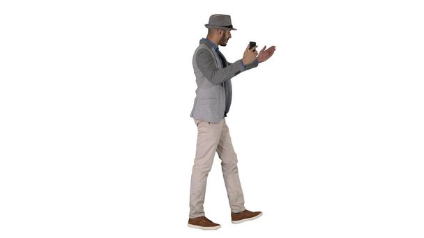 Hombre árabe atractivo en ropa casual grabación de vídeo para el blog en fondo blanco. - Foto, imagen