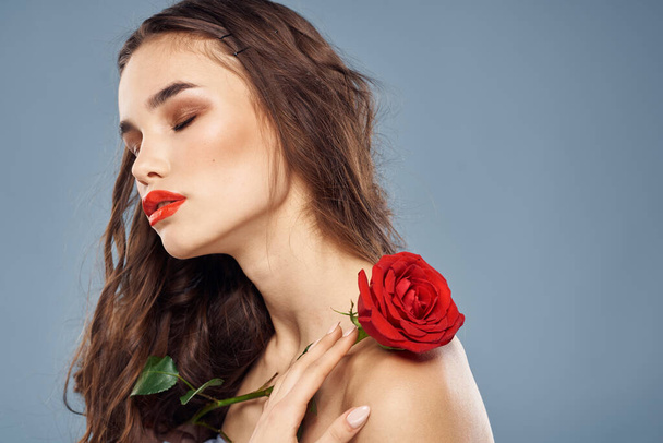 kobieta z różą w rękach nagie ramiona makijaż wieczorem czerwone usta - Zdjęcie, obraz