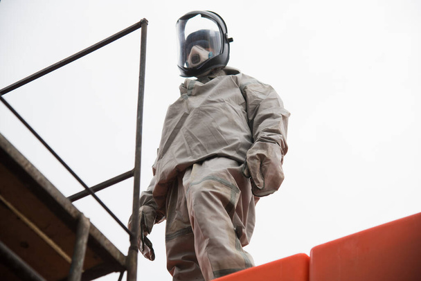Trabajador en traje protector al procesar locales industriales para protegerse contra la infección por COVID-19. Epidemia. Coronavirus - Foto, imagen
