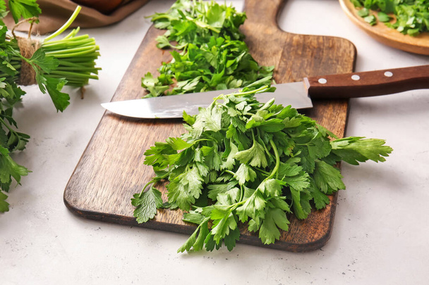 Cutting board with fresh parsley and knife on table - Foto, immagini