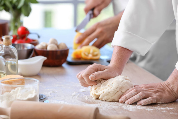 Female chef making dough in kitchen, closeup - Photo, Image