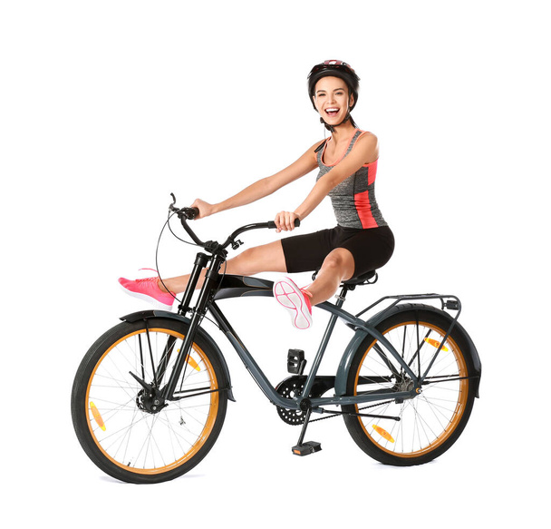 Female cyclist riding bicycle on white background - 写真・画像